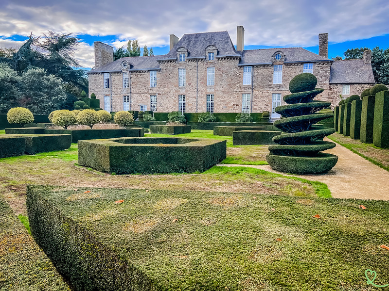 View of the boxwoods with the Ballue granite castle in the background